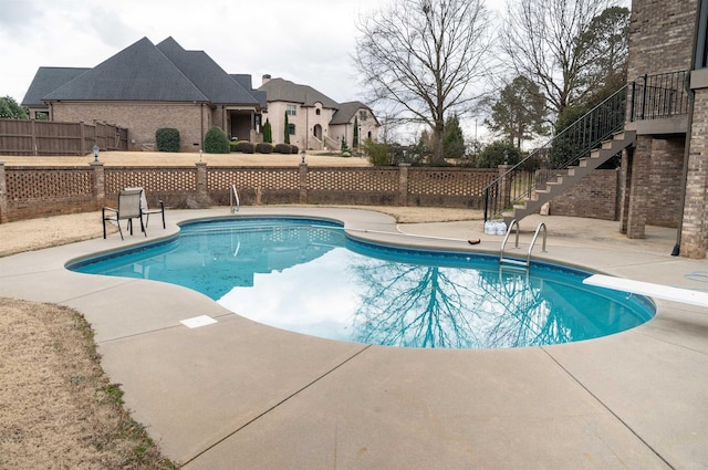 view of swimming pool featuring stairway, a fenced in pool, and fence