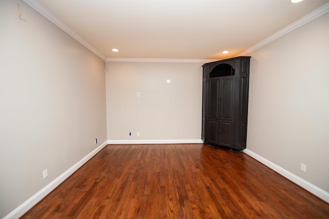 spare room with dark wood finished floors, crown molding, recessed lighting, and baseboards