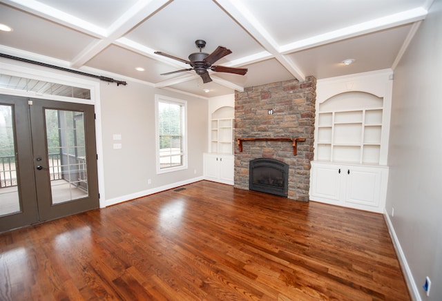 unfurnished living room featuring built in features, baseboards, coffered ceiling, and wood finished floors