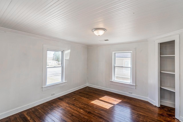 empty room with visible vents, baseboards, dark wood-style floors, and ornamental molding