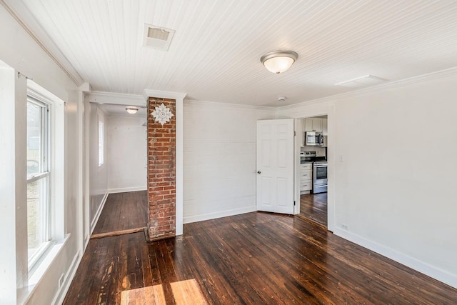 spare room featuring dark wood finished floors, visible vents, crown molding, and baseboards