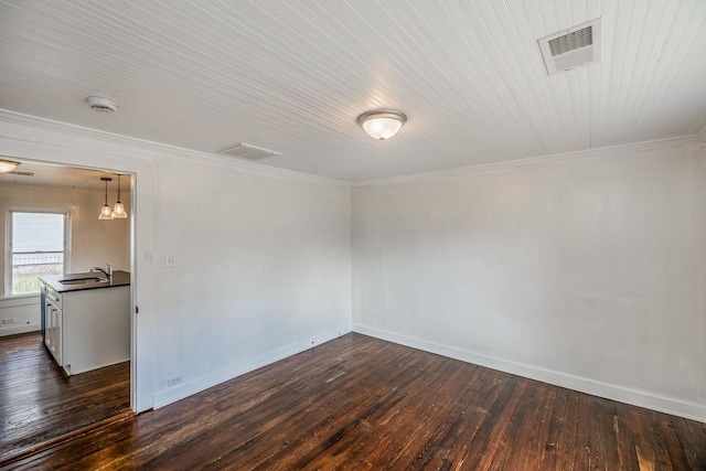 empty room with a sink, visible vents, and dark wood-type flooring