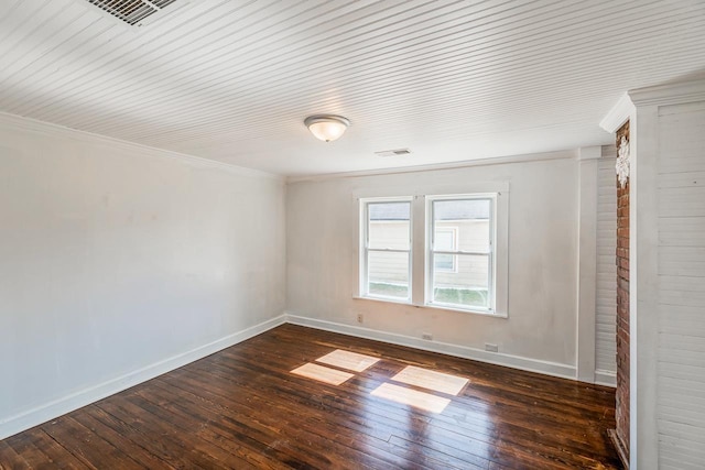 empty room featuring dark wood finished floors, visible vents, and baseboards