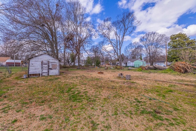 view of yard featuring a storage shed, an outdoor structure, and fence