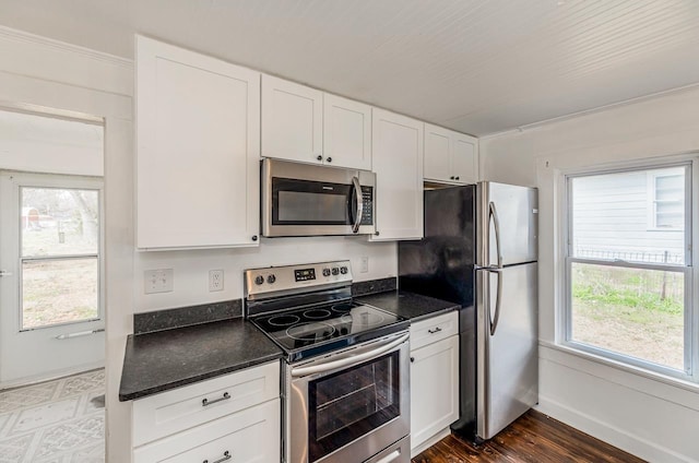 kitchen featuring dark wood-style floors, white cabinetry, stainless steel appliances, and baseboards