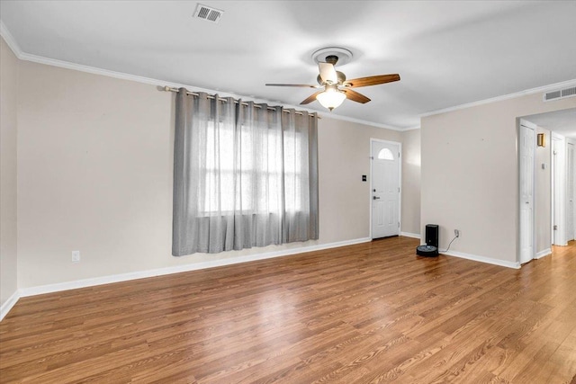 unfurnished living room with baseboards, wood finished floors, visible vents, and ornamental molding