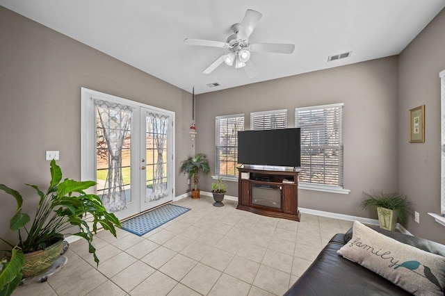 living room featuring light tile patterned floors, visible vents, french doors, and baseboards