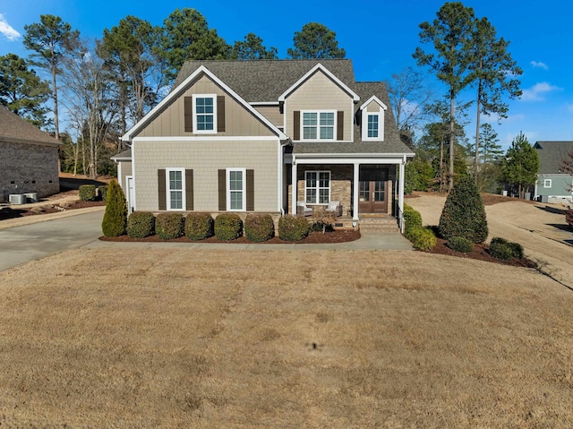 view of front of home with a front yard and a shingled roof