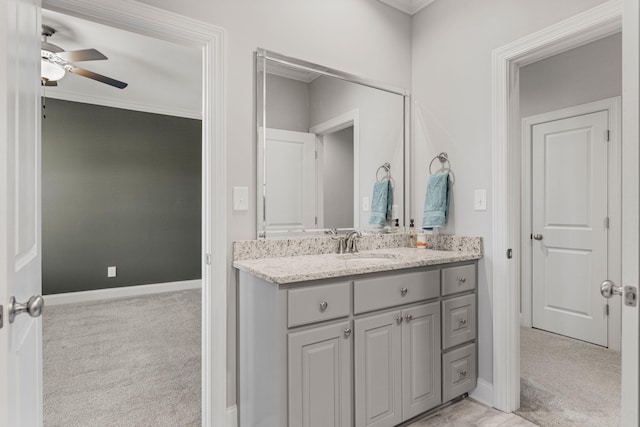 bathroom with baseboards, a ceiling fan, and vanity