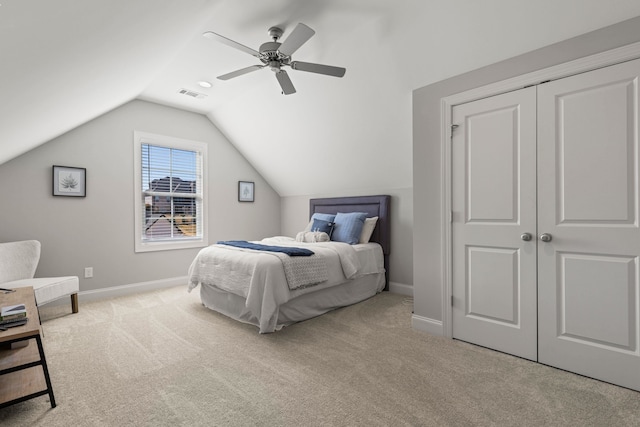 carpeted bedroom with visible vents, a ceiling fan, a closet, baseboards, and vaulted ceiling