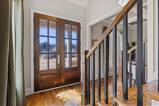 foyer entrance featuring french doors, wood finished floors, and stairway