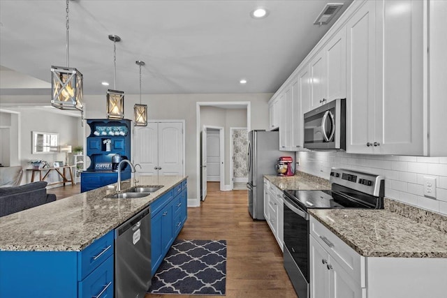 kitchen with blue cabinets, a sink, white cabinetry, appliances with stainless steel finishes, and dark wood-style flooring