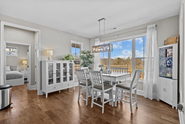 dining room with hardwood / wood-style floors, an inviting chandelier, and visible vents