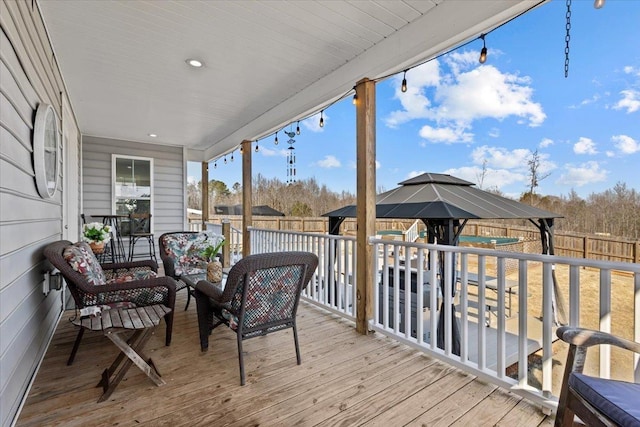 wooden terrace with a gazebo and fence