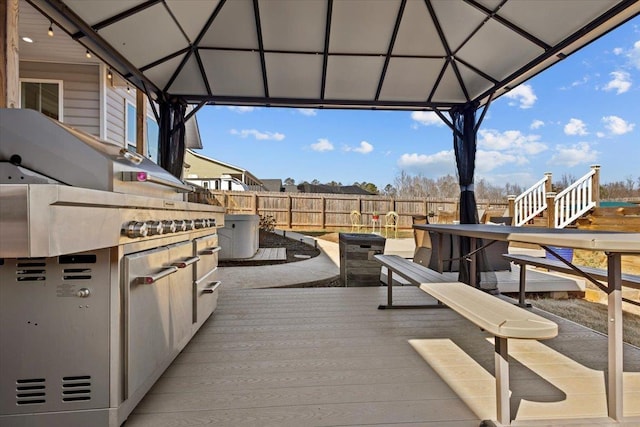 view of patio with a gazebo, a deck, and fence