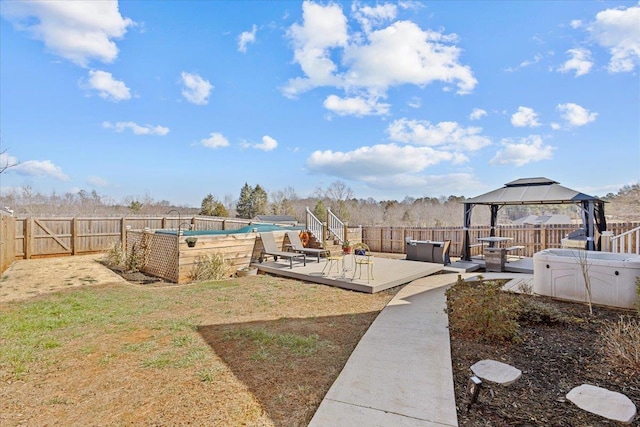 view of yard featuring a deck, a gazebo, a jacuzzi, and a fenced backyard