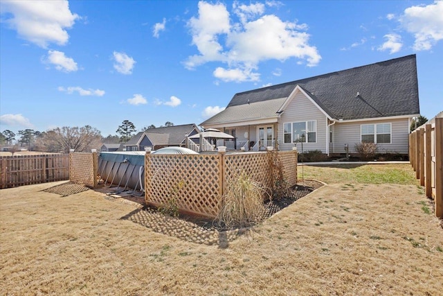 back of property with a yard and a fenced backyard