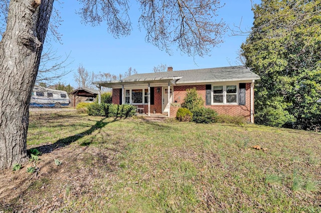 ranch-style house featuring a front yard, brick siding, and a chimney