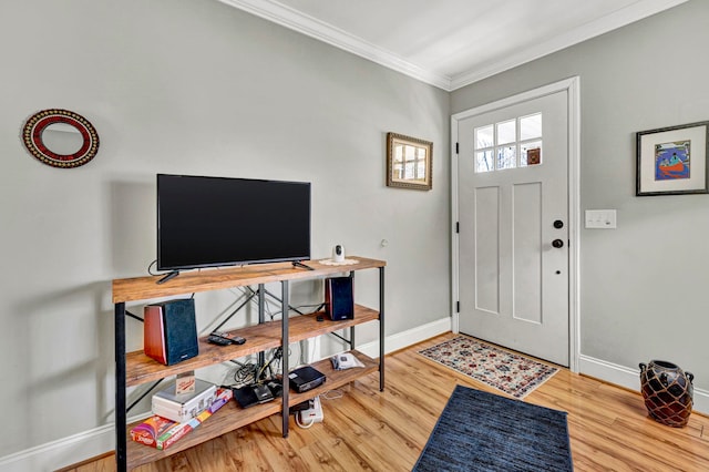 foyer featuring wood finished floors, baseboards, and ornamental molding