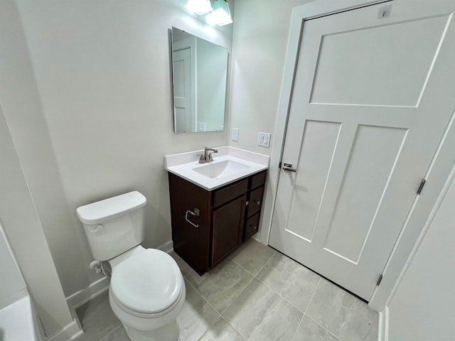 bathroom with baseboards, toilet, vanity, and tile patterned flooring