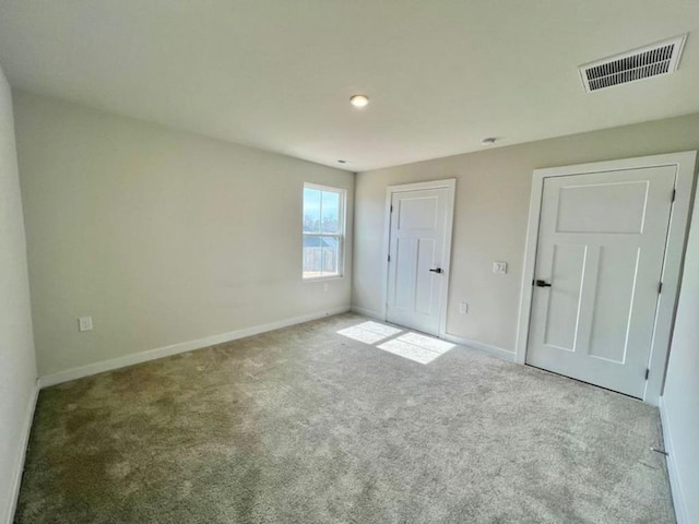 unfurnished bedroom with baseboards, visible vents, and carpet floors