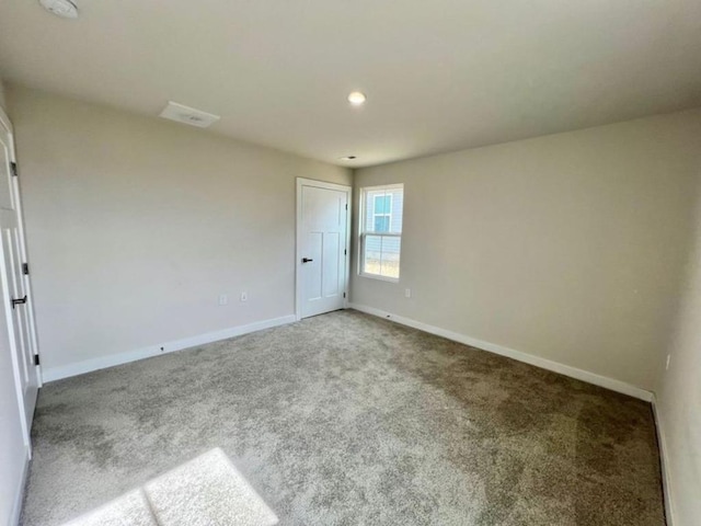 carpeted spare room featuring recessed lighting and baseboards