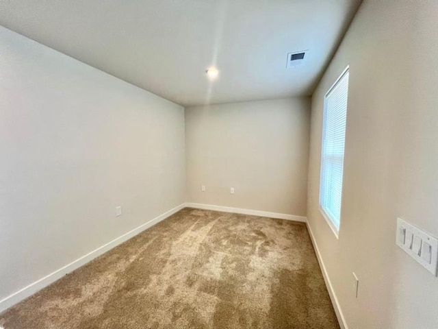 carpeted empty room with visible vents and baseboards