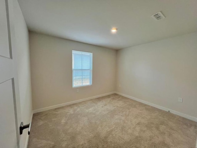 carpeted empty room with visible vents and baseboards