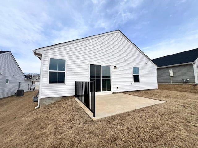 rear view of house with a yard, central air condition unit, and a patio