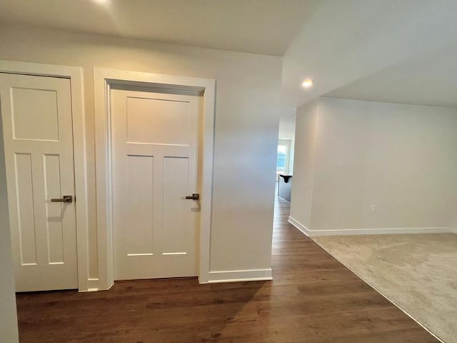 hallway with dark wood-style floors and baseboards