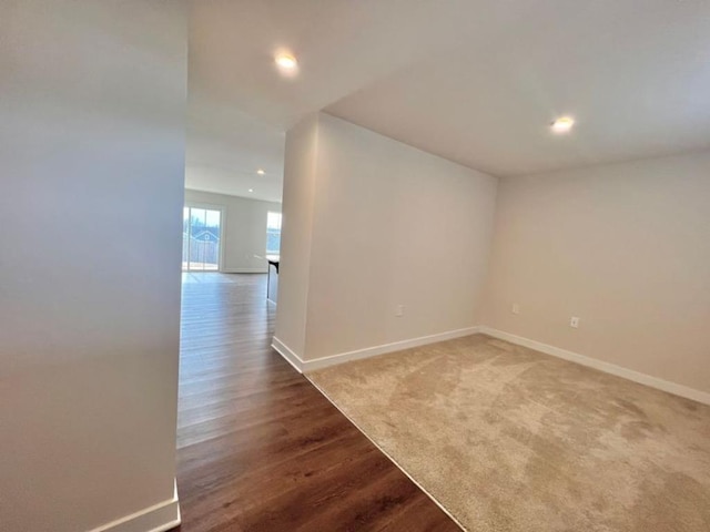 unfurnished room featuring recessed lighting, wood finished floors, and baseboards