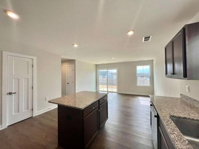 kitchen featuring stainless steel dishwasher, dark wood-type flooring, dark brown cabinets, and visible vents