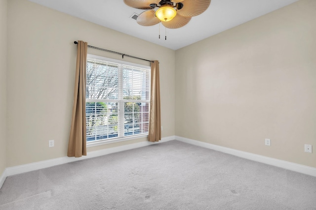 spare room with ceiling fan, baseboards, and light carpet