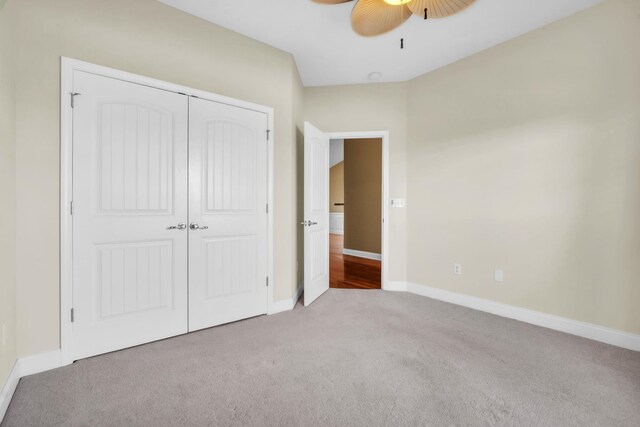 unfurnished bedroom with baseboards, a closet, carpet floors, and ceiling fan