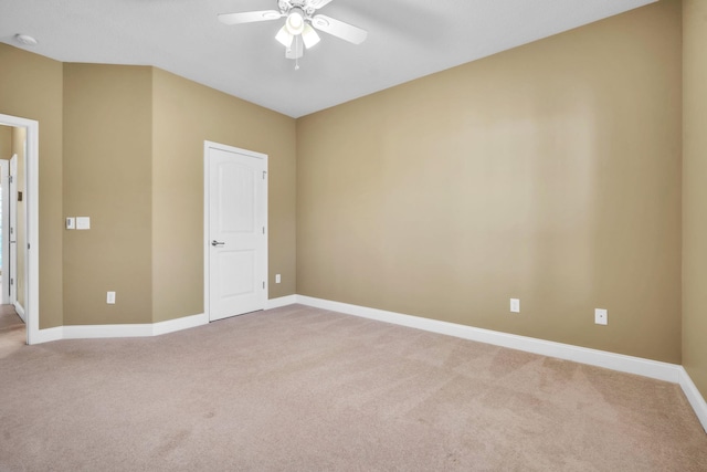 unfurnished room featuring baseboards, light carpet, and ceiling fan