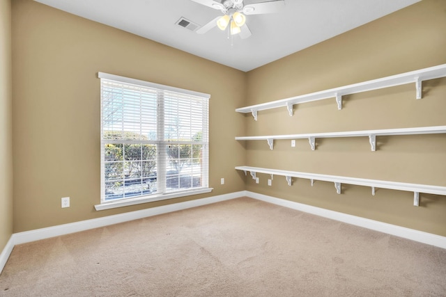 carpeted spare room with visible vents, ceiling fan, and baseboards