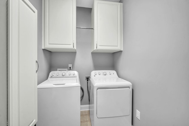 washroom featuring cabinet space and independent washer and dryer