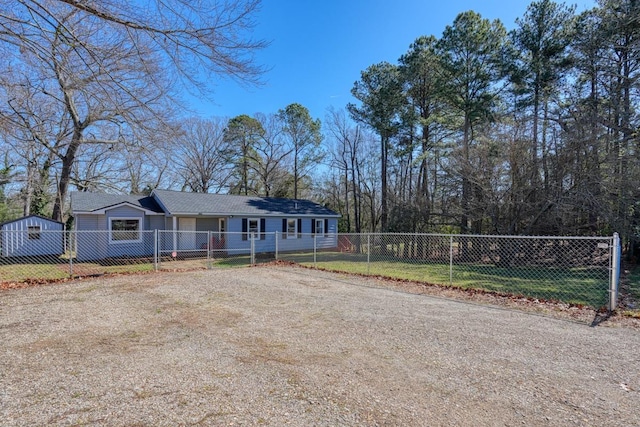 view of front facade featuring a fenced front yard, a front lawn, and dirt driveway