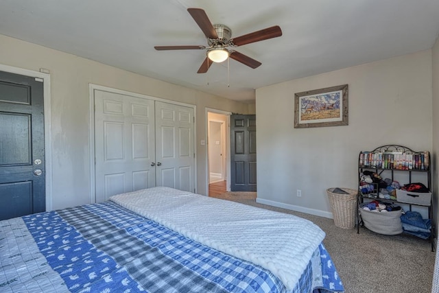 carpeted bedroom with a closet, baseboards, and ceiling fan