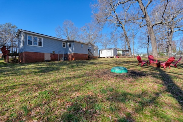 view of yard featuring a fire pit, stairs, and an outdoor structure