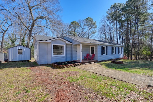 view of front of property with a storage unit, an outbuilding, a porch, and a front yard