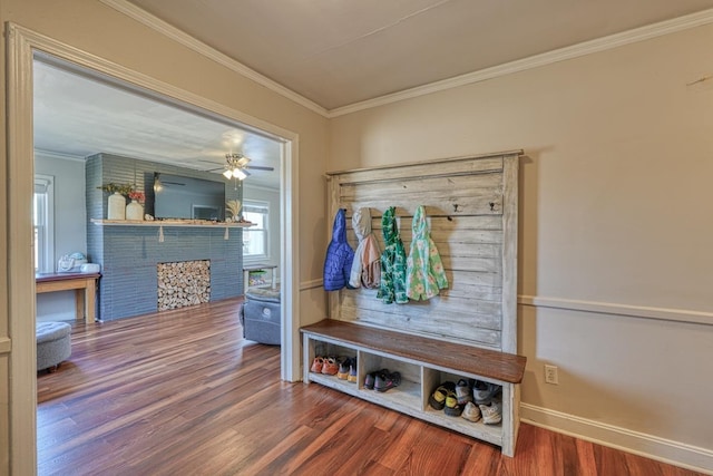 mudroom with a fireplace, wood finished floors, baseboards, and ornamental molding