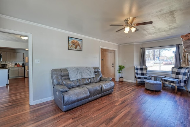 living area with a ceiling fan, crown molding, baseboards, and dark wood-style flooring