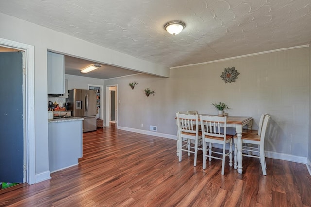 dining area featuring baseboards, visible vents, dark wood-style flooring, and a textured ceiling