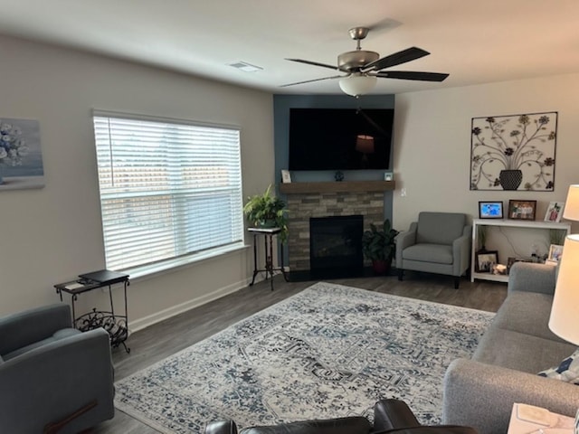 living room featuring ceiling fan, visible vents, wood finished floors, and a fireplace