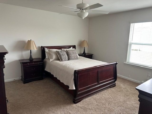 bedroom with light carpet, ceiling fan, and baseboards