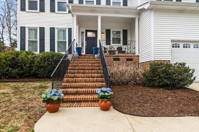 doorway to property with a porch and a garage