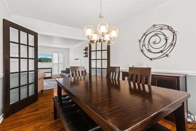 dining room with dark wood finished floors, a chandelier, and ornamental molding