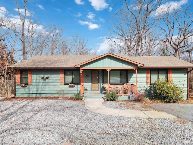 ranch-style home with a porch and roof with shingles