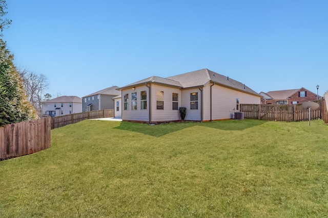 back of property with central AC unit, a yard, and a fenced backyard